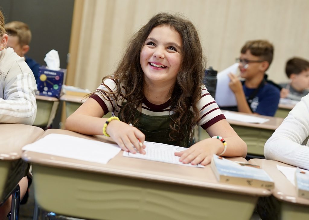 Female student laughing at desk