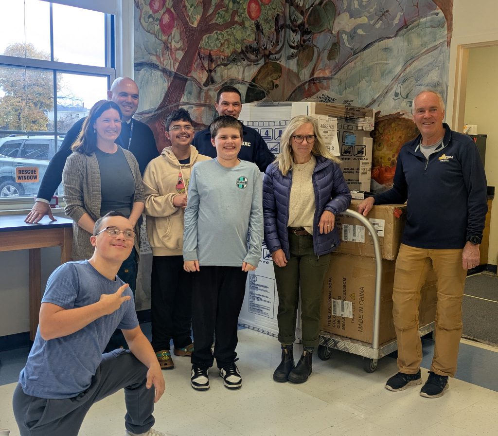 five people standing in front of boxes