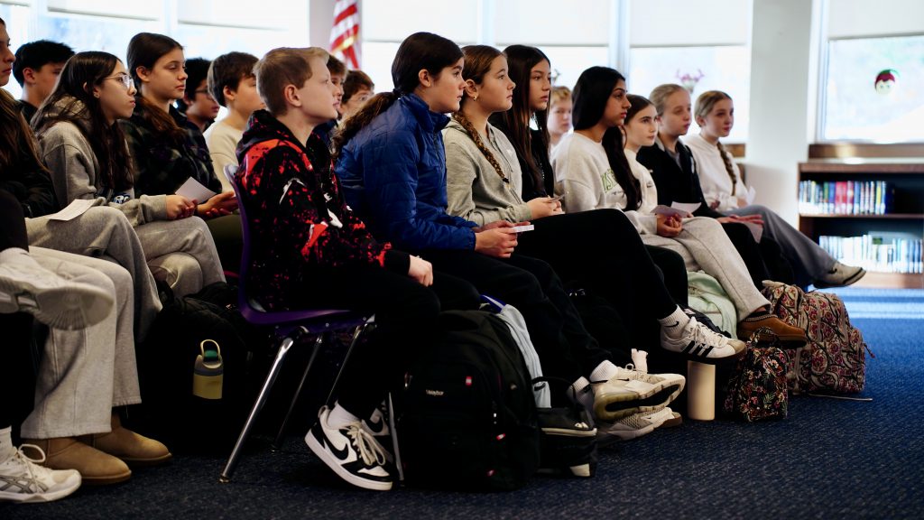 students in a library sitting on chairs