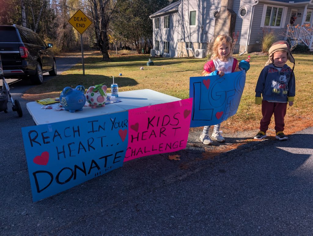 two children holding up a sign that says "kids heart challenge"