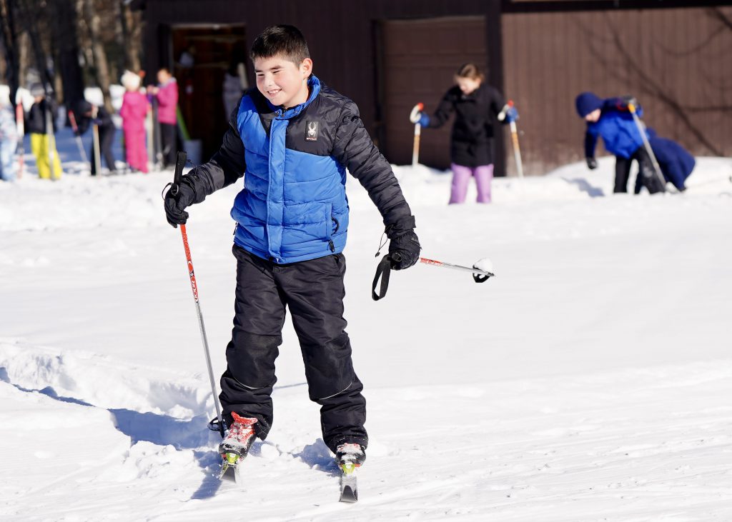 student cross-country skiing outside