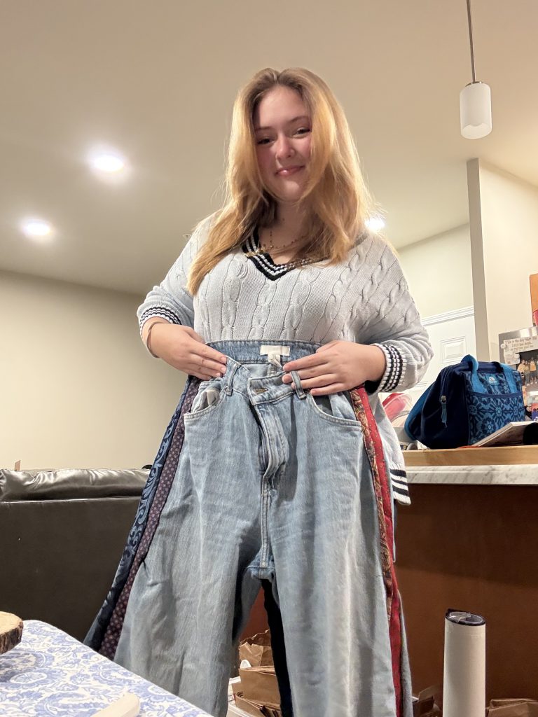 female student holding up colorful jean pants