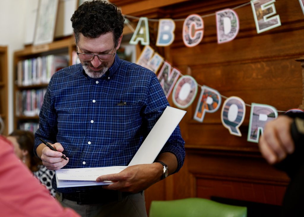 Man signing book with a pen