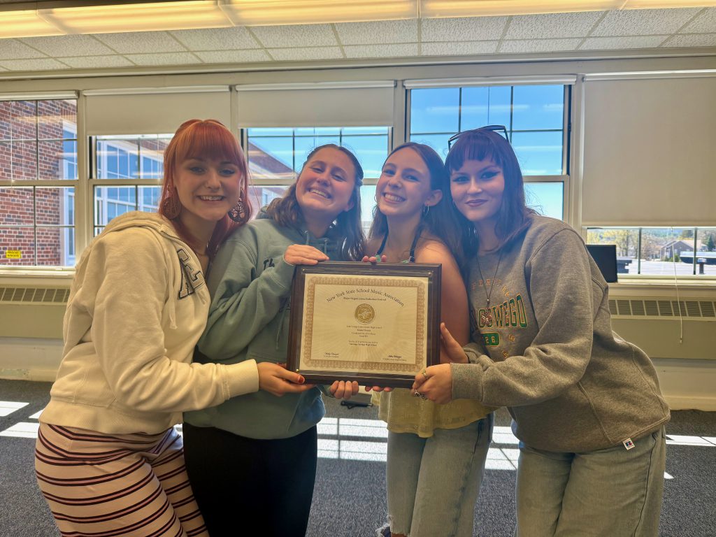 four female students hold a plaque that says gold with distinction