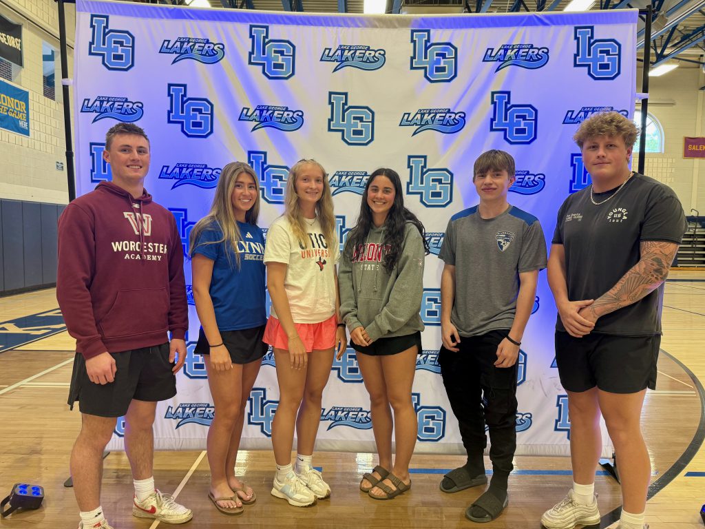  six students standing in front of a banner that says "LG"