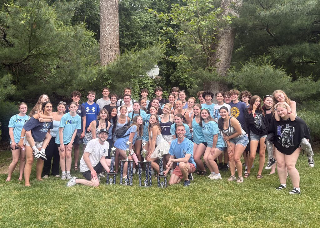 large group of students standing behind four trophies