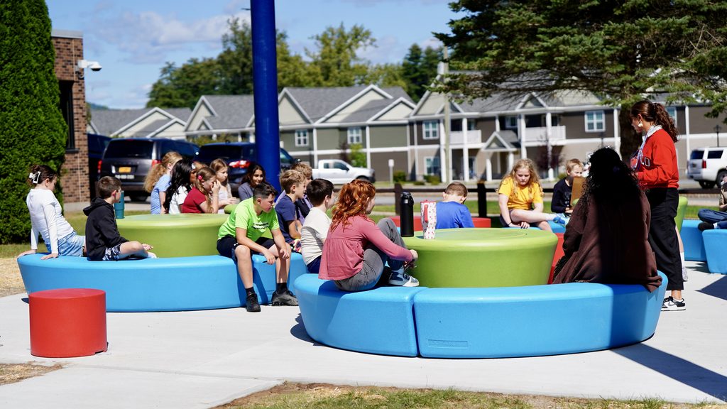 students sitting outside on colorful seating